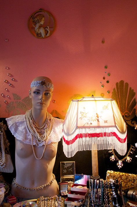 Eclectic interior of a vintage boutique in Helsinki with antique jewelry and retro lamps, perfect for cultural immersion and hidden gem hunting.