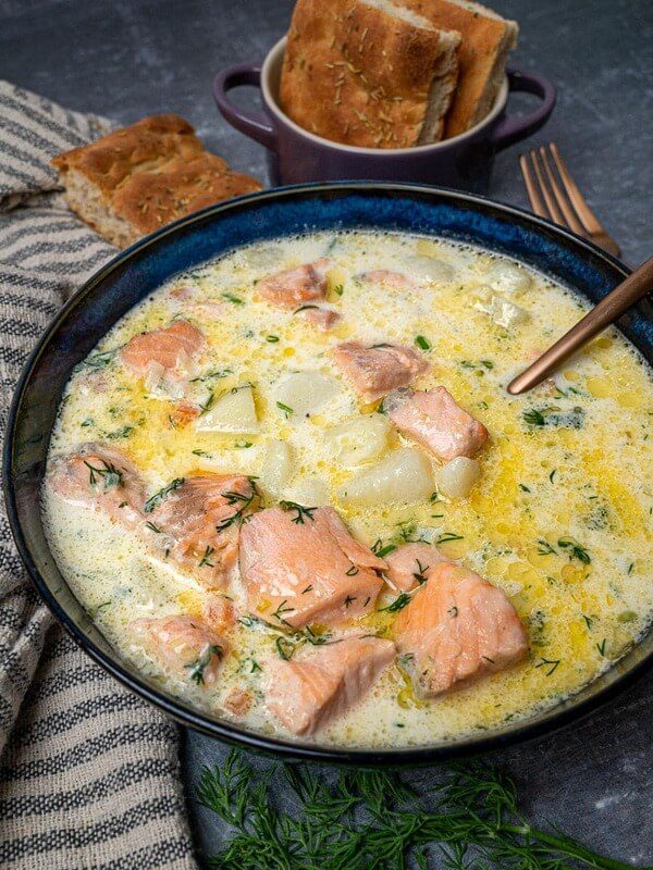 A close-up of a creamy Finnish salmon soup (Lohikeitto) with fresh dill and bread, a must-try traditional dish at Helsinki's harbor market.