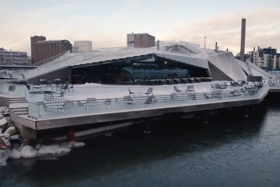 Modern wooden architecture of Löyly Public Sauna in Helsinki during winter, offering authentic Finnish sauna experiences by the frozen sea